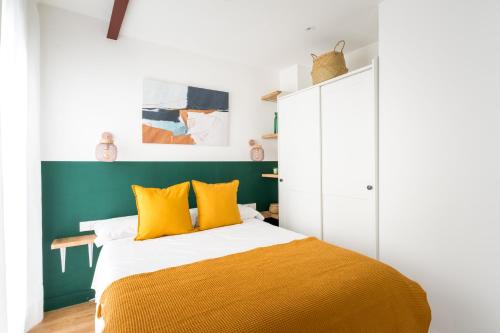 1 dormitorio con 1 cama con almohadas amarillas en BeHouse Campana, en Sevilla