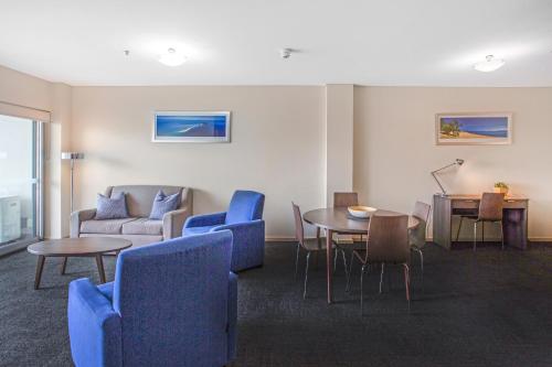 a living room filled with furniture and a table at Hume Serviced Apartments in Adelaide