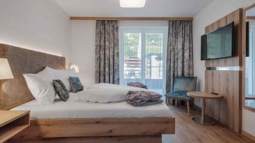 a bedroom with a large bed and a window at Aktiv- & Gesundheitsresort das GXUND - Thermeneintritt inklusive in Bad Hofgastein