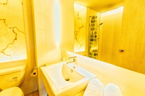 a bathroom with a sink and a toilet and a mirror at Atlantis Residence in Jomtien Beach