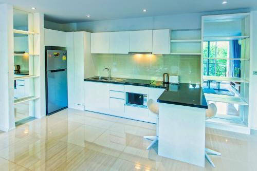 a kitchen with white cabinets and a black counter top at Atlantis Residence in Jomtien Beach