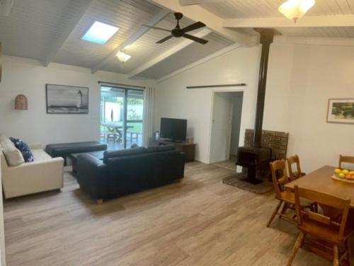 a living room with a couch and a table at Abbey Beach Shack in Busselton