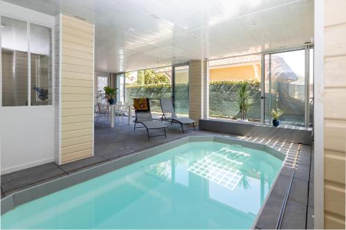 a swimming pool in a house with a patio at Le Loft Mauresque Centre Ville piscine privée intérieure chauffée in Arcachon