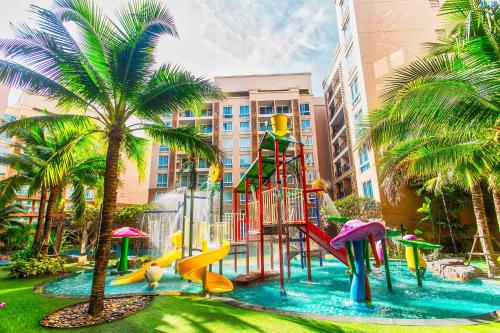 a playground with a slide in a park with palm trees at Atlantis Residence in Jomtien Beach