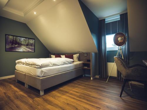 een slaapkamer met een bed, een bureau en een raam bij Schlichte Hof GmbH in Bielefeld
