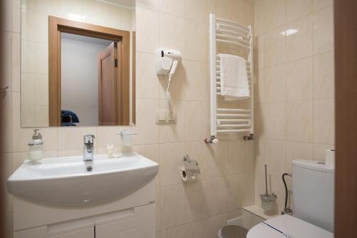 bagno con lavandino, servizi igienici e specchio di ОРАНТА a Truskavec'