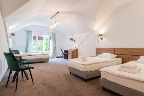 1 dormitorio con 2 camas, mesa y sillas en Hotel Odejewscy, en Chojnice