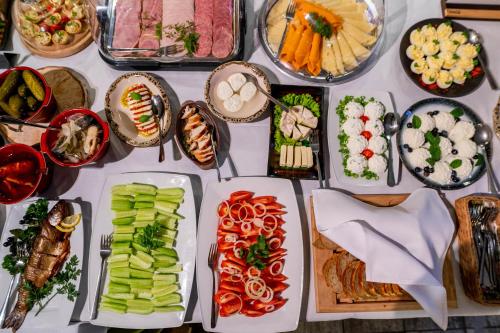 a table filled with different types of food on plates at Hotel Odejewscy in Chojnice