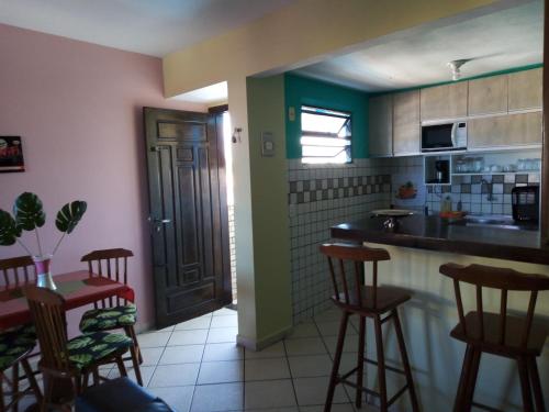 cocina con encimera y taburetes en una habitación en Condomínio Euro, en Natal