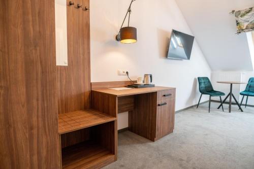 a wooden desk in a room with two chairs at Hotel Odejewscy in Chojnice