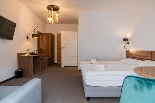 a hotel room with two beds and a table at Hotel Odejewscy in Chojnice