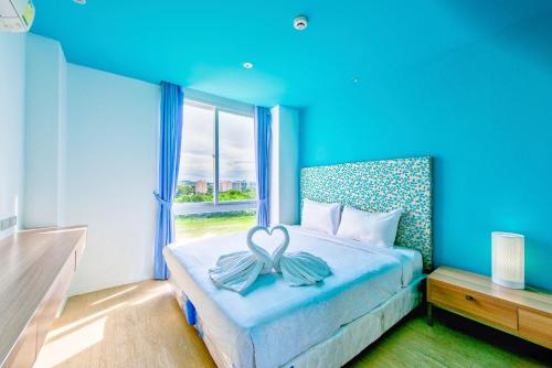 um quarto azul com uma cama com um laço em Atlantis Residence em Praia de Jomtien