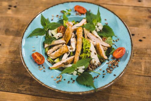 a blue plate of food on a wooden table at Hotel Odejewscy in Chojnice