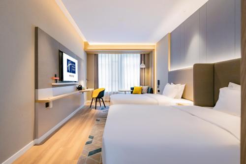 a hotel room with two beds and a desk at Holiday Inn Express Xi'an High Tech Zone North by IHG in Xi'an