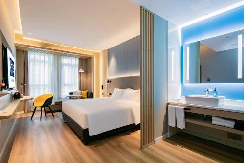 a hotel room with a bed and a desk and a sink at Holiday Inn Express Xi'an High Tech Zone North by IHG in Xi'an