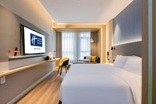 a hotel room with a large bed and a flat screen tv at Holiday Inn Express Xi'an High Tech Zone North by IHG in Xi'an