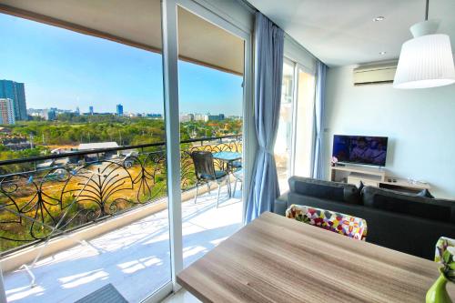 a living room with a couch and a large window at Atlantis Residence in Jomtien Beach