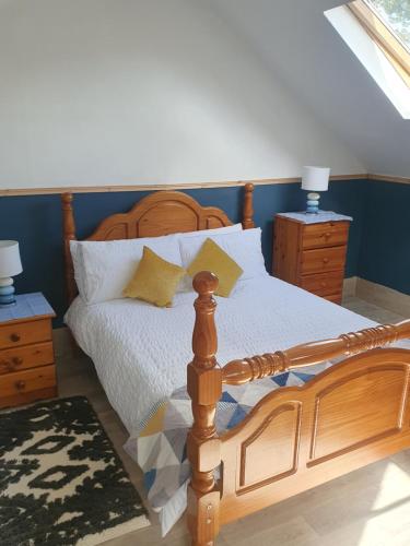 a bedroom with a wooden bed and two night stands at Grange cottages in Edenderry