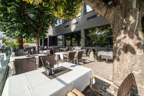 a restaurant with tables and chairs and a building at Rufi's Hotel Innsbruck in Innsbruck