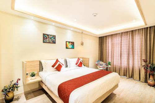 a hotel room with a bed and a window at Hotel Jagadish International-Sankey Road in Bengaluru