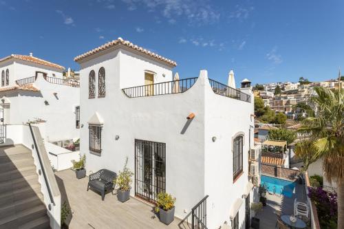 a white house with a balcony and a swimming pool at Villa La Casita Burriana Nerja in Nerja
