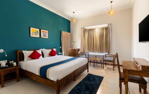 1 dormitorio con cama, mesa y escritorio en Dheergarh Palace, en Udaipur