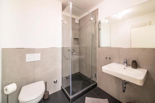 a bathroom with a toilet and a sink and a shower at Glück Auf Appartements Kaiserstraße Mülheim in Mülheim an der Ruhr
