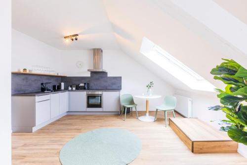 a kitchen with white cabinets and a table and chairs at Glück Auf Appartements Kaiserstraße Mülheim in Mülheim an der Ruhr