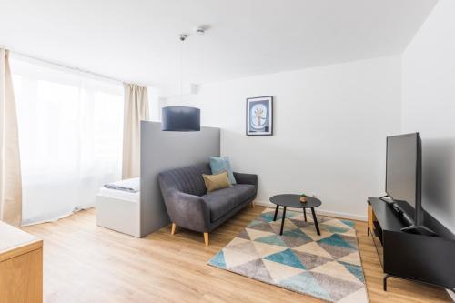 a living room with a couch and a tv at Glück Auf Appartements Kaiserstraße Mülheim in Mülheim an der Ruhr