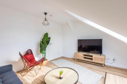 a living room with a couch and a tv at Glück Auf Appartements Kaiserstraße Mülheim in Mülheim an der Ruhr