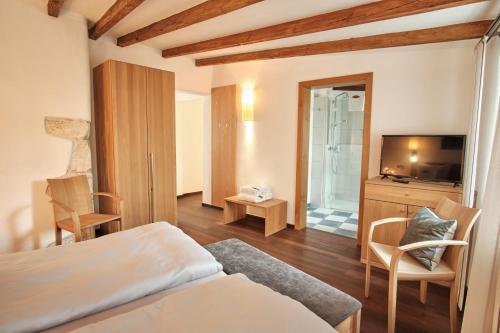 a hotel room with a bed and a television at Turmhotel zum Erasmus in Kelheim