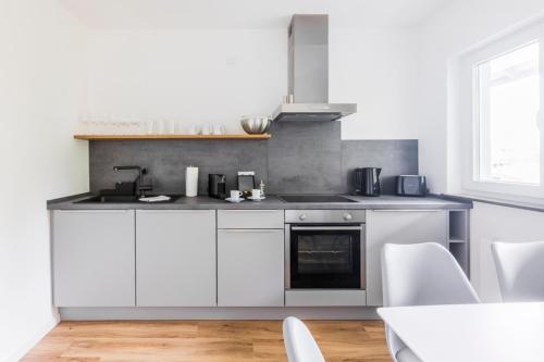 a kitchen with white cabinets and a stove at Glück Auf Appartements Kaiserstraße Mülheim in Mülheim an der Ruhr