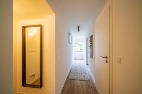a hallway with a door and a mirror on a wall at Glück Auf Appartements Kaiserstraße Mülheim in Mülheim an der Ruhr
