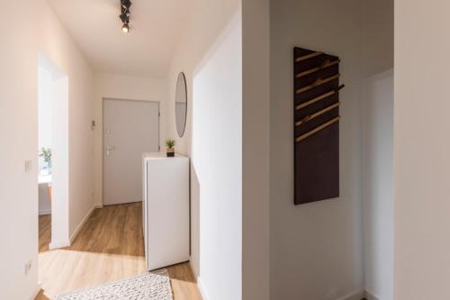 a living room with a white refrigerator and a hallway at Glück Auf Appartements Kaiserstraße Mülheim in Mülheim an der Ruhr