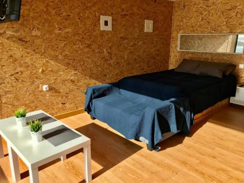a small bedroom with a bed and a table at Vistas al mar 2 Canabal in A Coruña