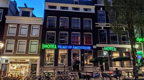 a group of buildings on a city street at night at Heart of Amsterdam Hostel in Amsterdam