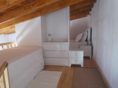 a white bedroom with a bed and a mirror at Casinhas Proença - Family in Aljezur