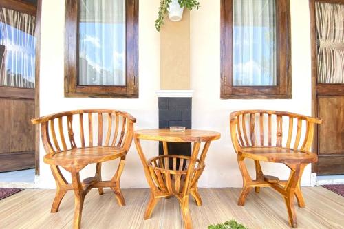 two wooden chairs and a table and a table and chairs at Homestay Banteng Adventure Dieng Mitra RedDoorz in Dieng