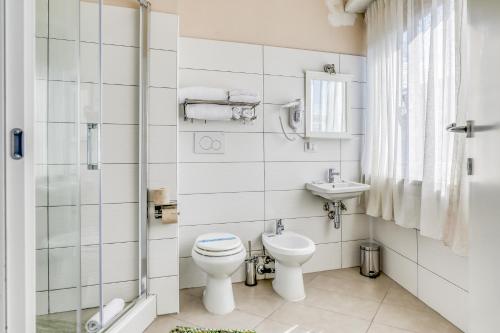 a white bathroom with a toilet and a sink at Asso Residence Centro in Terni