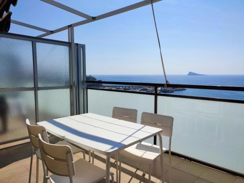 a white table and chairs on a balcony with the ocean at Flats Friends Atlantida in Benidorm