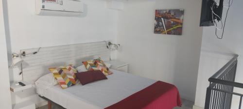 a white bedroom with a bed with two pillows at valencialoft in Valencia