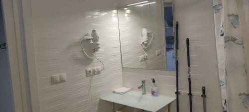 a bathroom with a shower with a sink and a mirror at valencialoft in Valencia