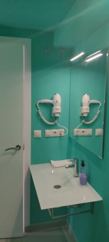 a bathroom with a sink and a green wall at valencialoft in Valencia