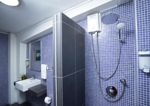 ein blau gefliestes Bad mit einer Dusche und einem Waschbecken in der Unterkunft 1-80 Collection Penthouse by TrulyCyprus in Limassol