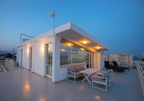 a balcony with chairs and a table on a building at 1-80 Collection Penthouse by TrulyCyprus in Limassol