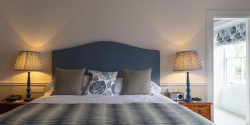 a bedroom with a large bed with two lamps at Farlam Hall Hotel & Restaurant in Brampton