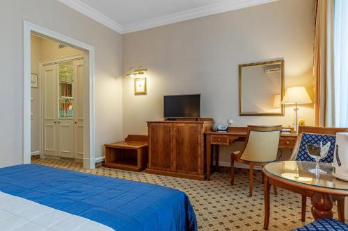 a hotel room with a bedroom with a bed and a desk at Natsionalny Hotel in Kyiv