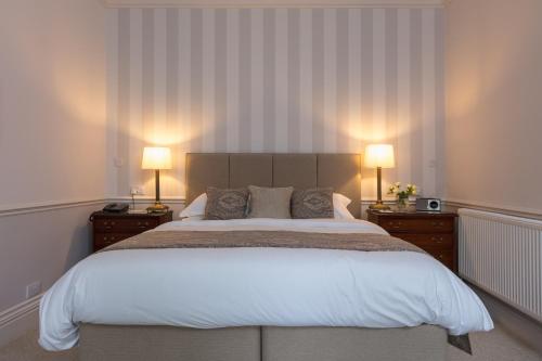 a bedroom with a large bed with two lamps at Farlam Hall Hotel & Restaurant in Brampton