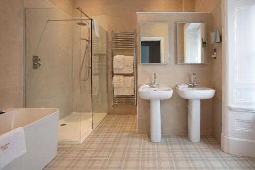 a bathroom with two sinks and a shower at Farlam Hall Hotel & Restaurant in Brampton