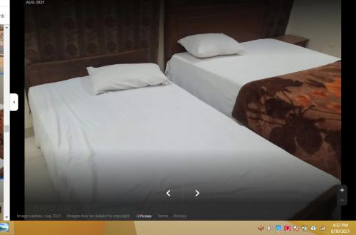 two beds sitting next to each other in a room at Grace Hotel in Gobindpur
